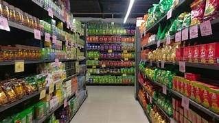 Aisle in a grocery store lined with shelves filled with various packaged snacks and food products.